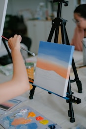 a person is painting a picture on a canvas