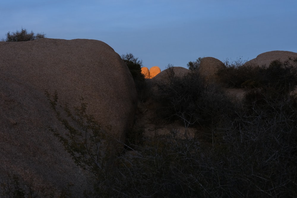 the sun is setting behind a rock formation