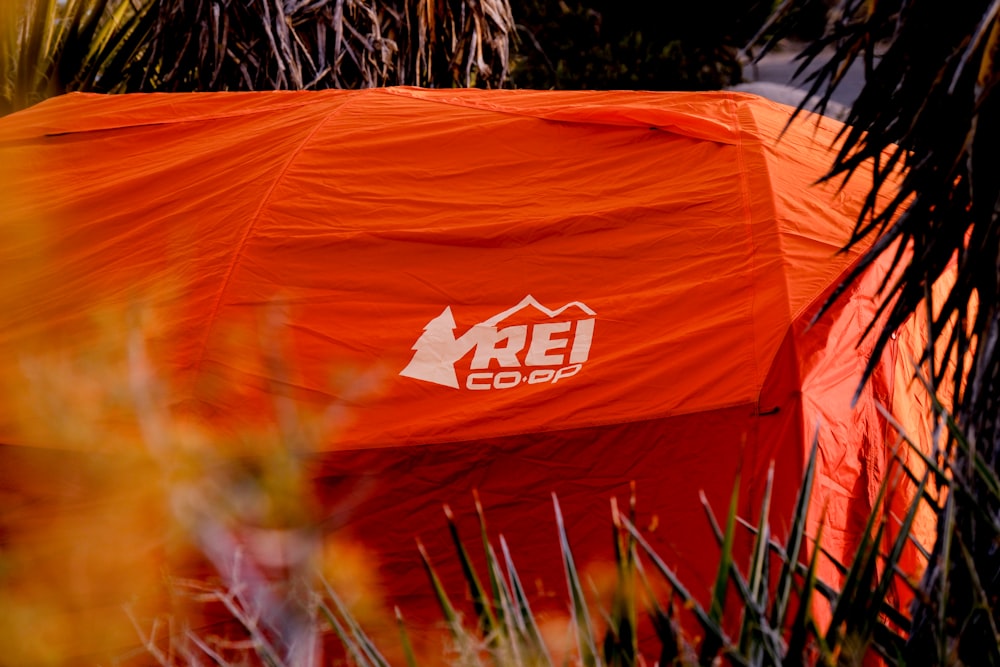 an orange tent with a white rel logo on it