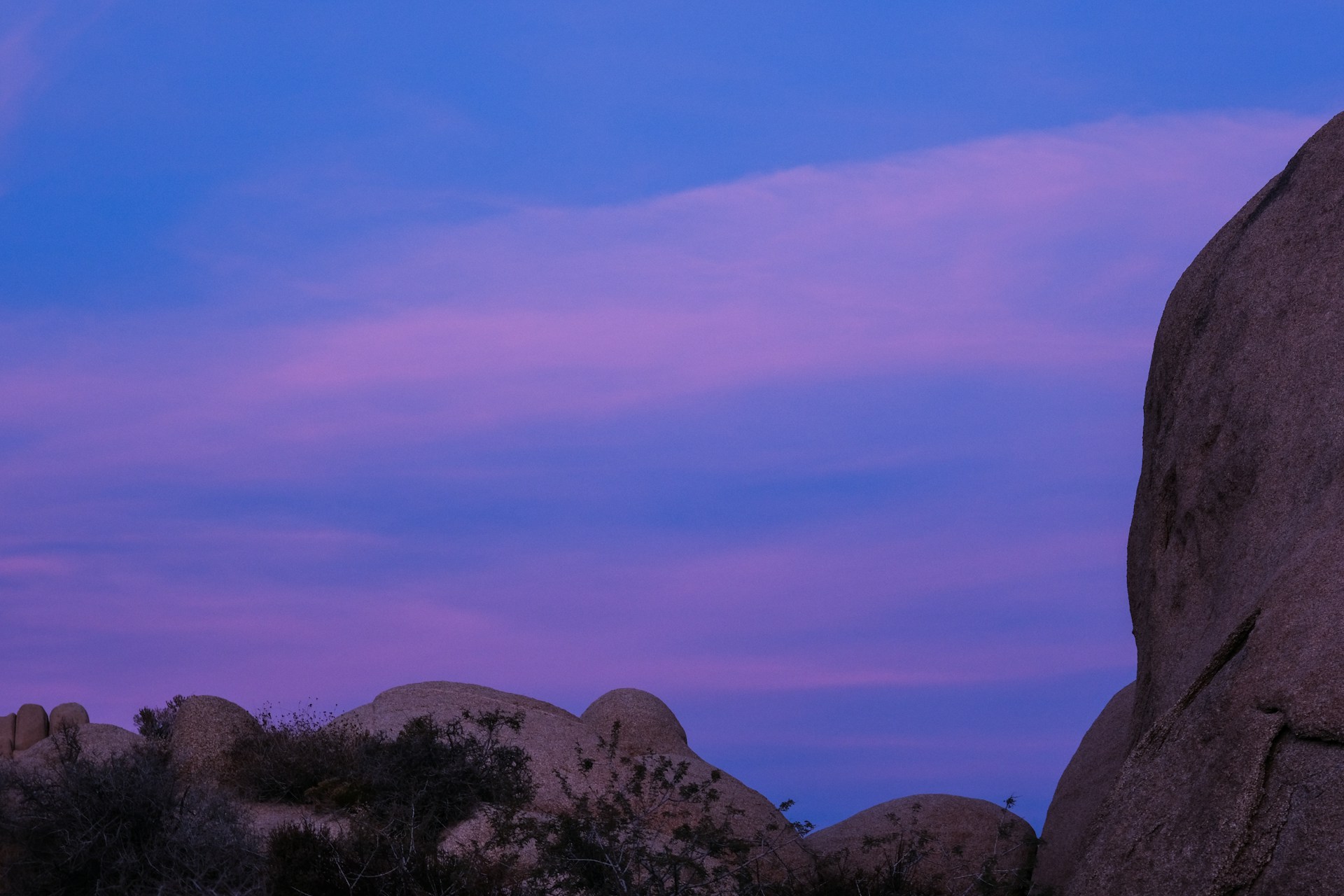 A serene landscape of a planet's surface, showcasing unique rock formations and colorful skies.