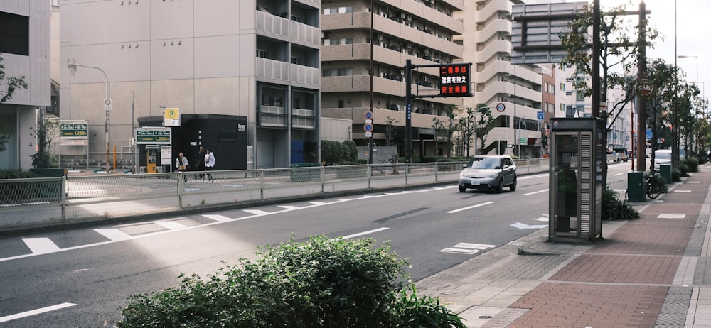 a car driving down a street next to tall buildings