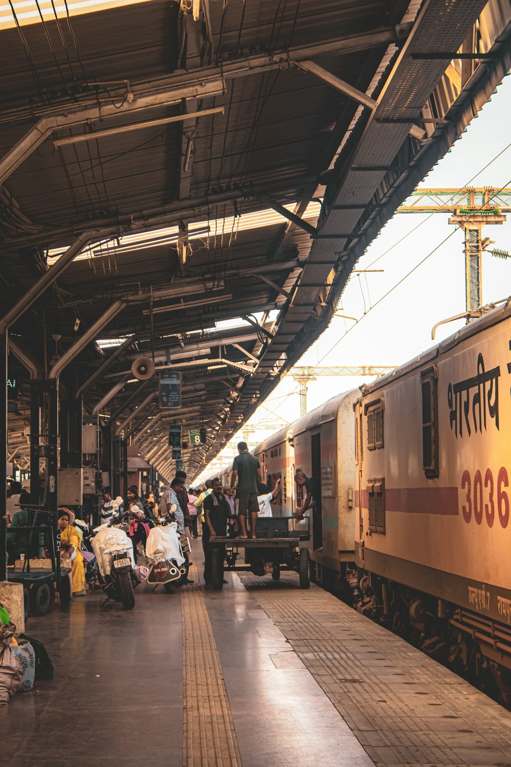 Un grupo de personas de pie junto a un tren en una estación de tren