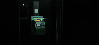 A dimly lit prison phone booth with static-filled audio waves visualized around the handset.