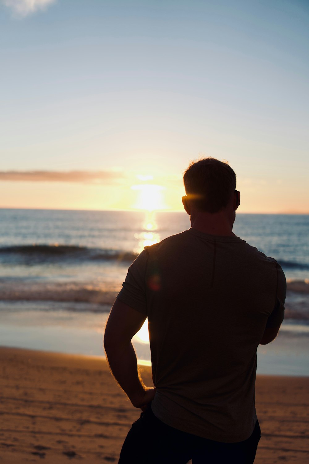 a man standing on top of a beach next to the ocean