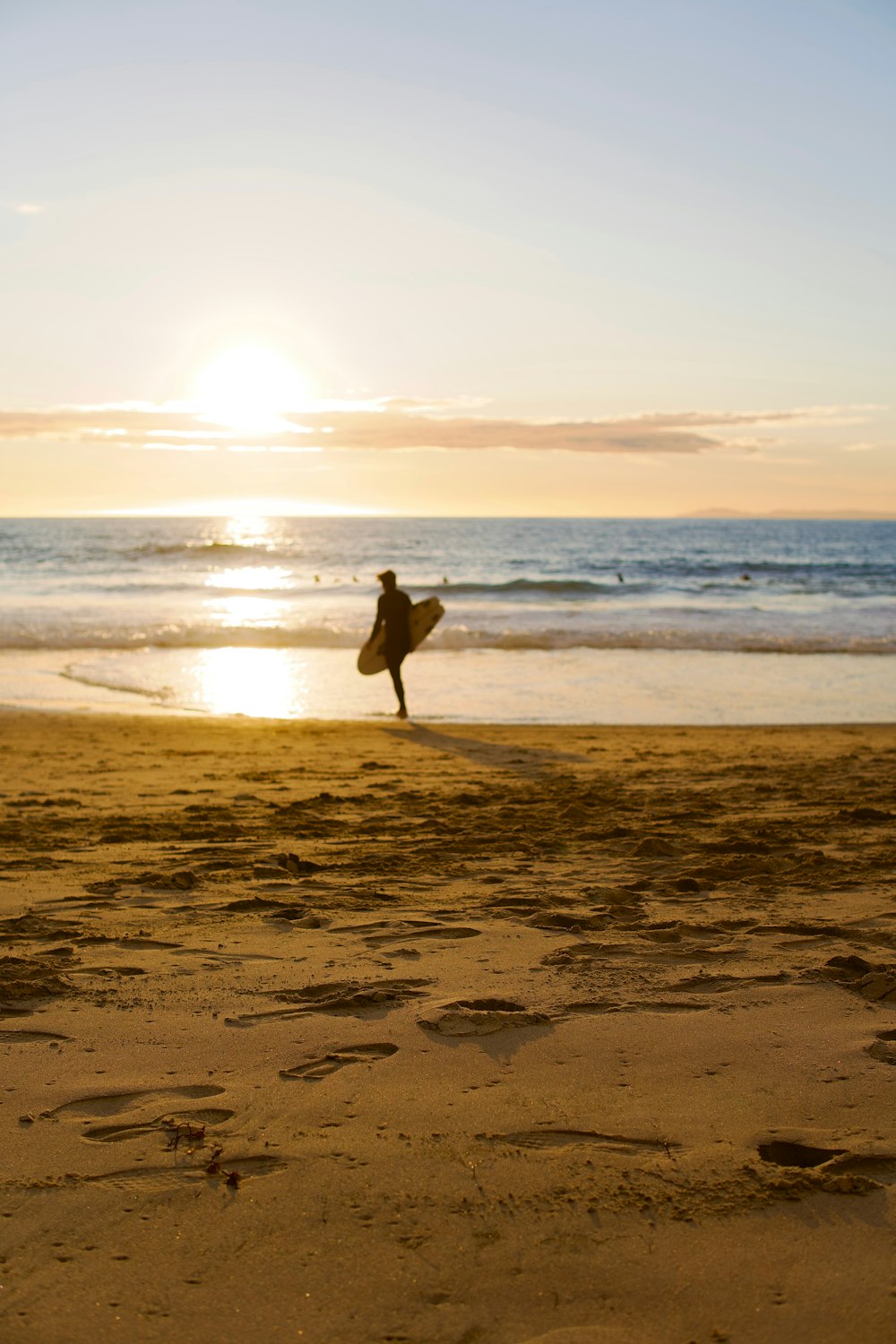 a person holding a surfboard on a beach