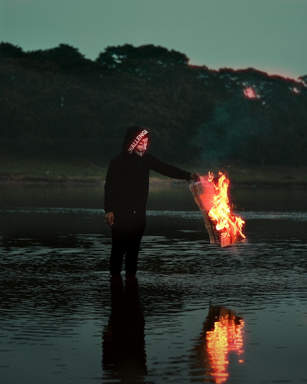 a person wearing a neon mask holding a fire