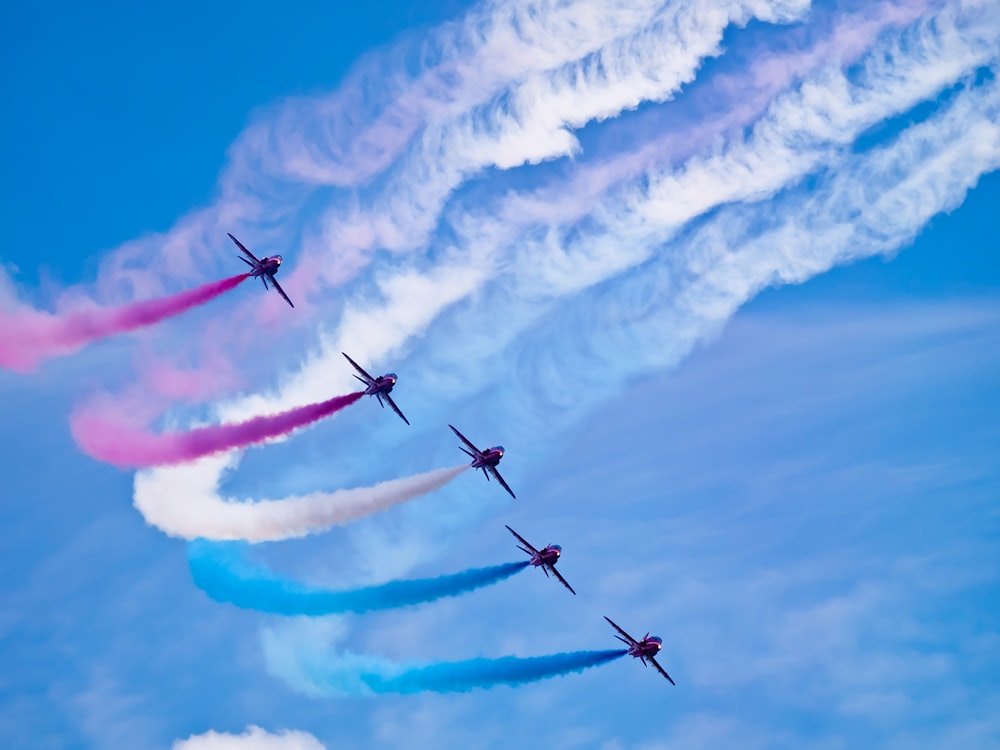 a group of airplanes flying through a blue sky