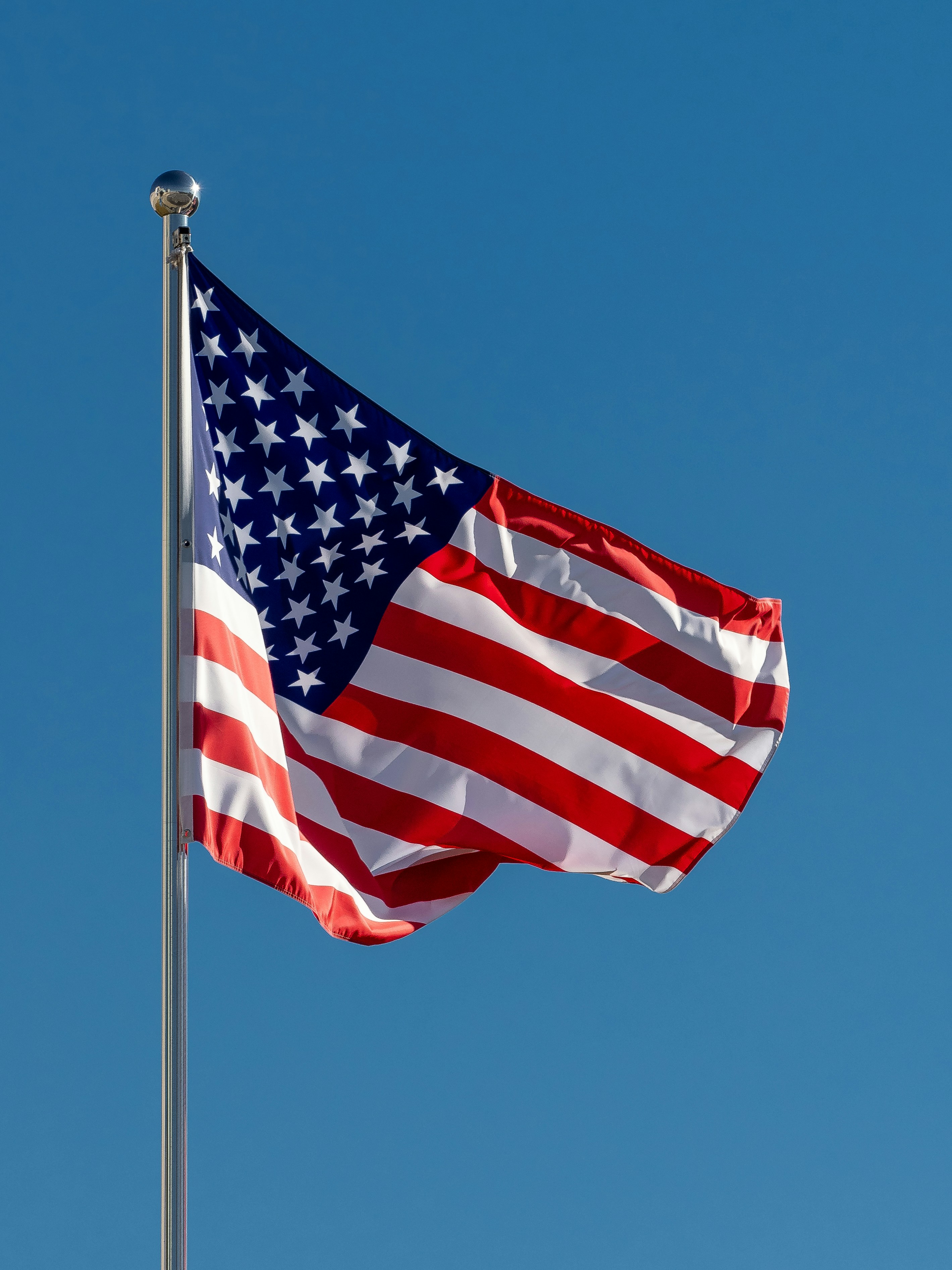 an american flag waving in the wind on a clear day
