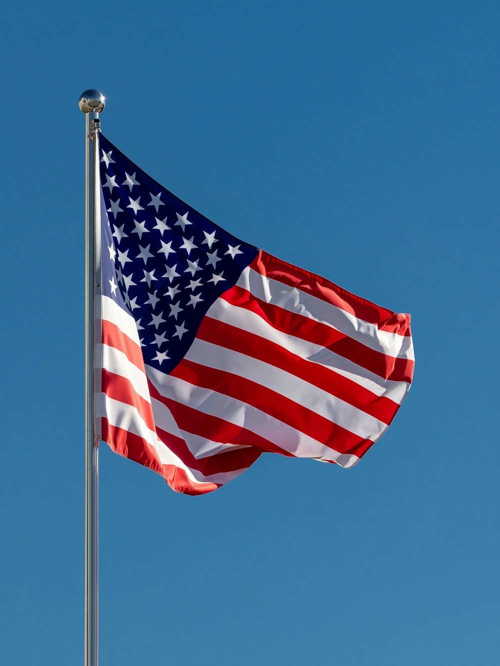 an american flag waving in the wind on a clear day