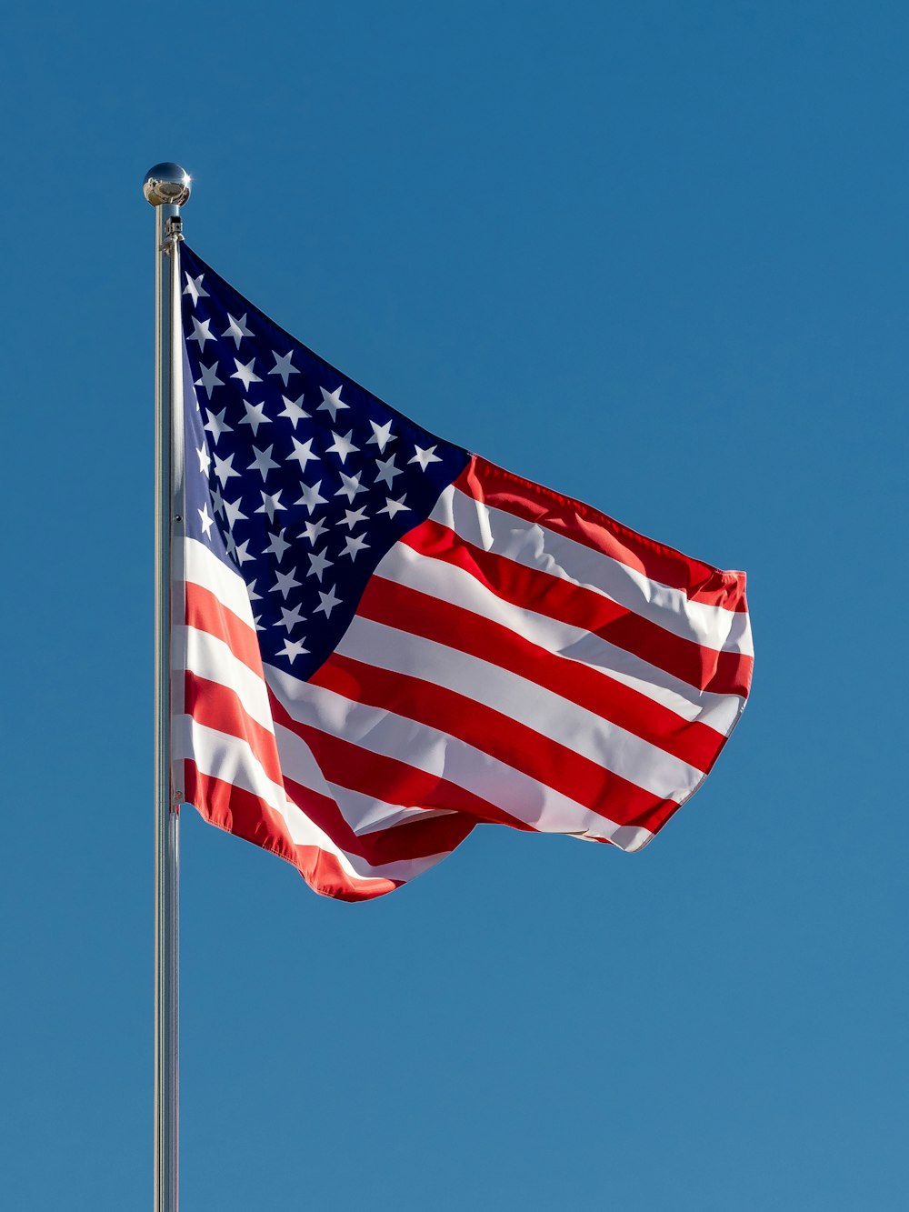 Una bandera estadounidense ondeando al viento en un día despejado