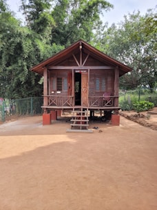 a small wooden building sitting on top of a dirt field