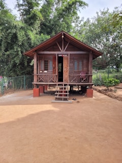 a small wooden building sitting on top of a dirt field