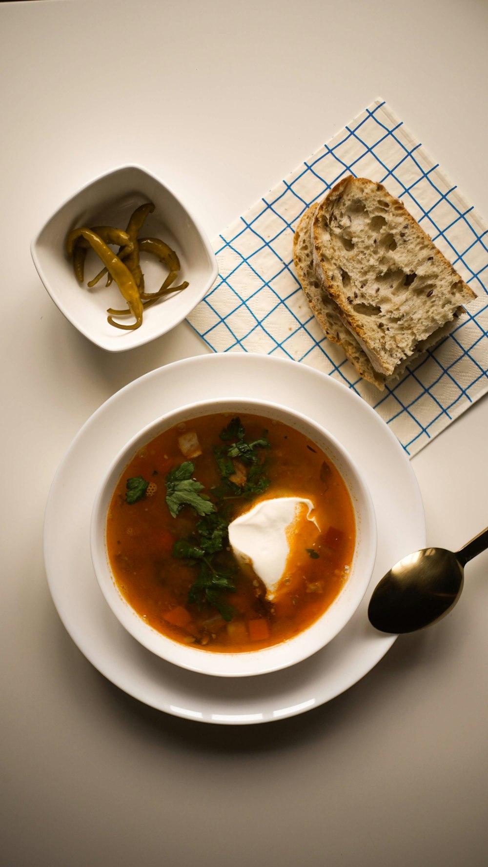 uma tigela de sopa e uma colher sobre uma mesa