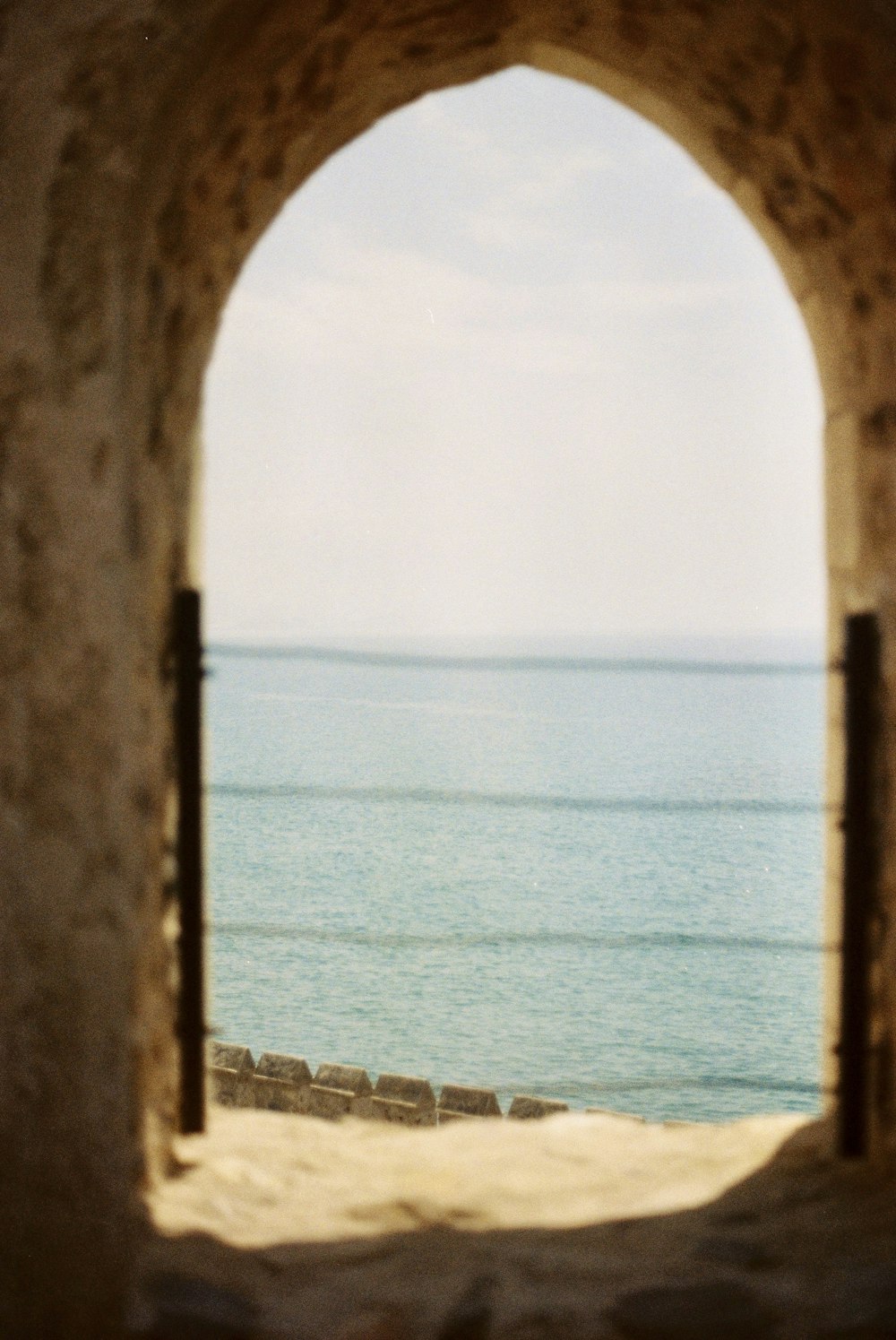 a view of a body of water through an arch