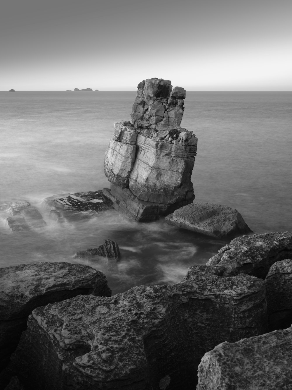Una foto en blanco y negro de rocas en el océano