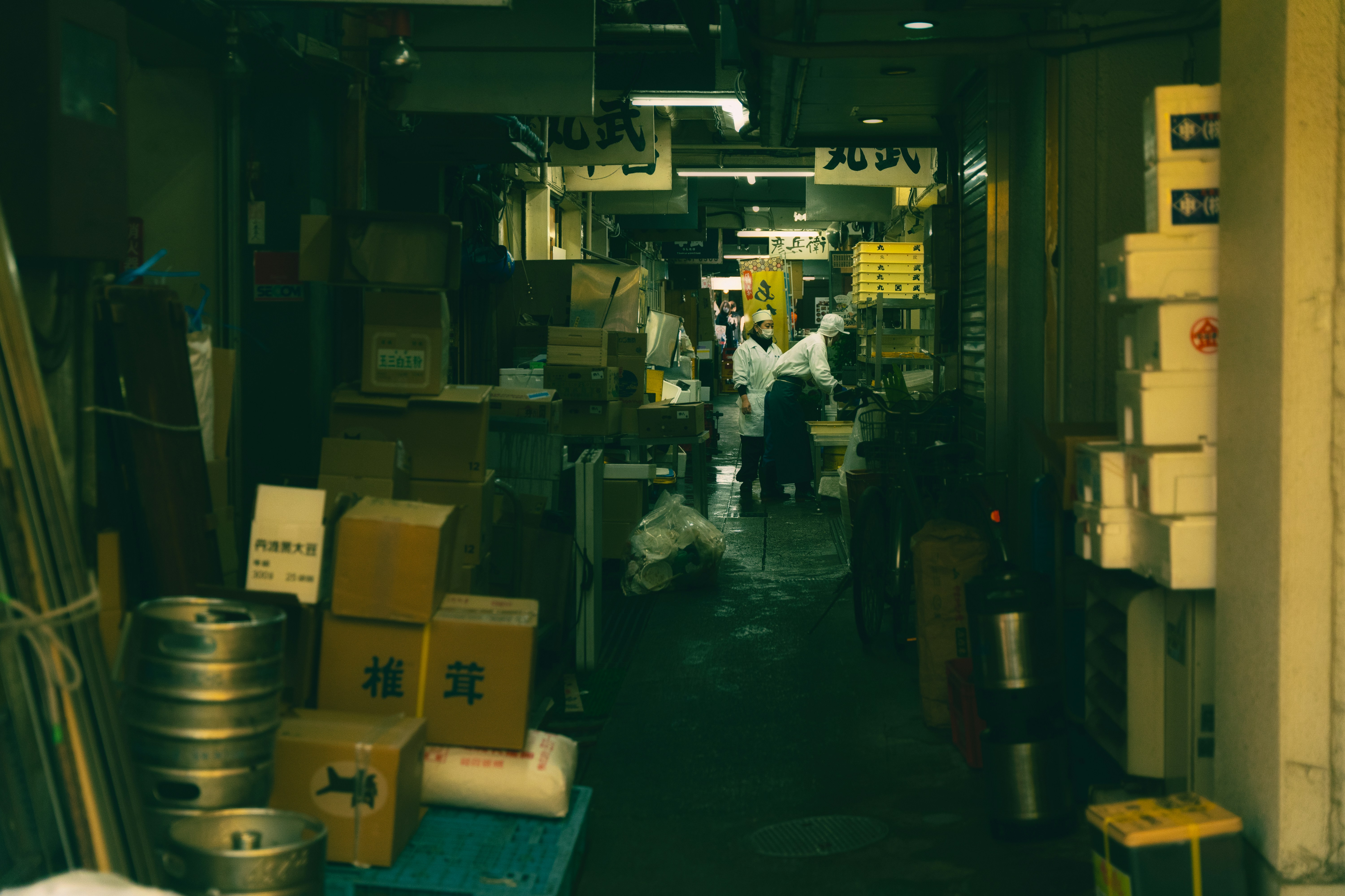 a narrow alley way with people walking through it, 