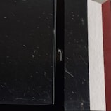 Close-up of painter’s brush adding red paint to interior window frame.