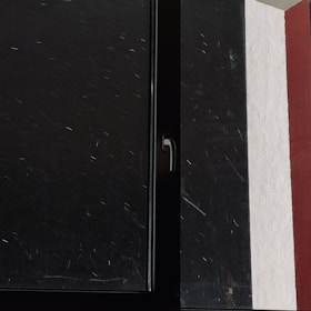 A close-up of a window frame freshly painted in soft cream color, highlighting smooth brush strokes.