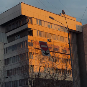 The college building bathed in warm morning sunlight with clear signage.