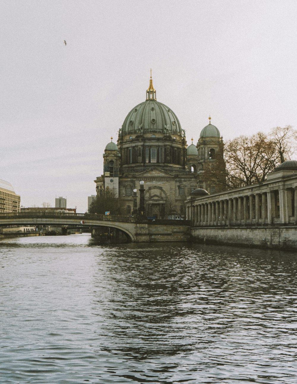 a bridge over a body of water with a building in the background