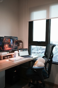 A desktop computer setup with a large monitor and keyboard in a cozy office.