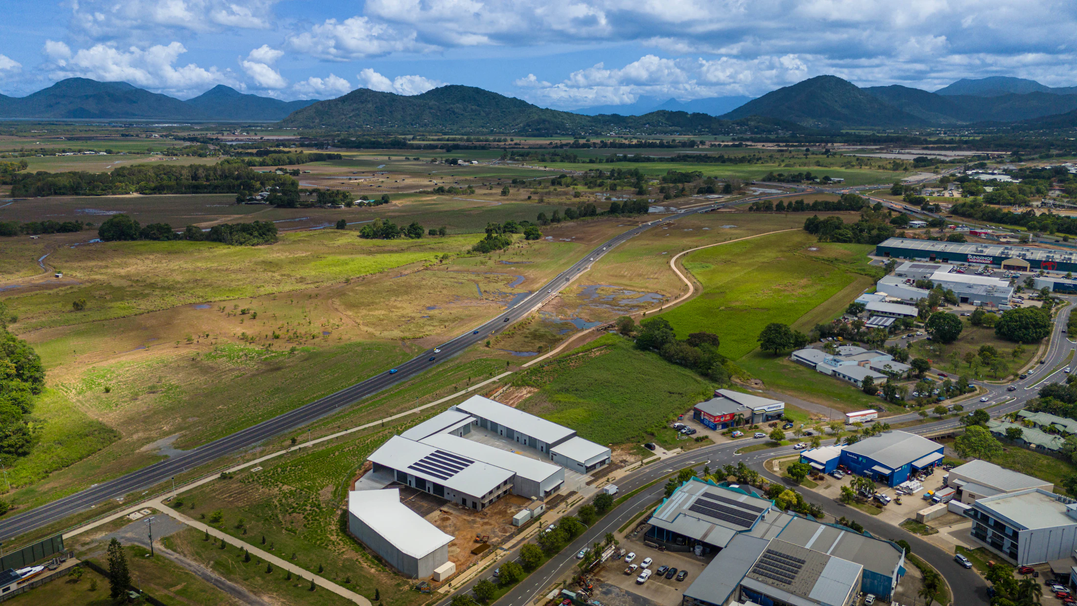 Pogled iz zraka na industrijsko območje z gorami v ozadju.