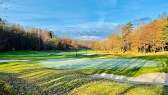 A vibrant photo of golfers teeing off under a clear autumn sky at Myrtle Beach.