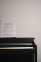Black and white photo of a piano with sheet music resting on the stand.