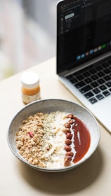 A cozy breakfast scene with a bowl of gluten-free cereal and the howfirst app open on a tablet nearby.