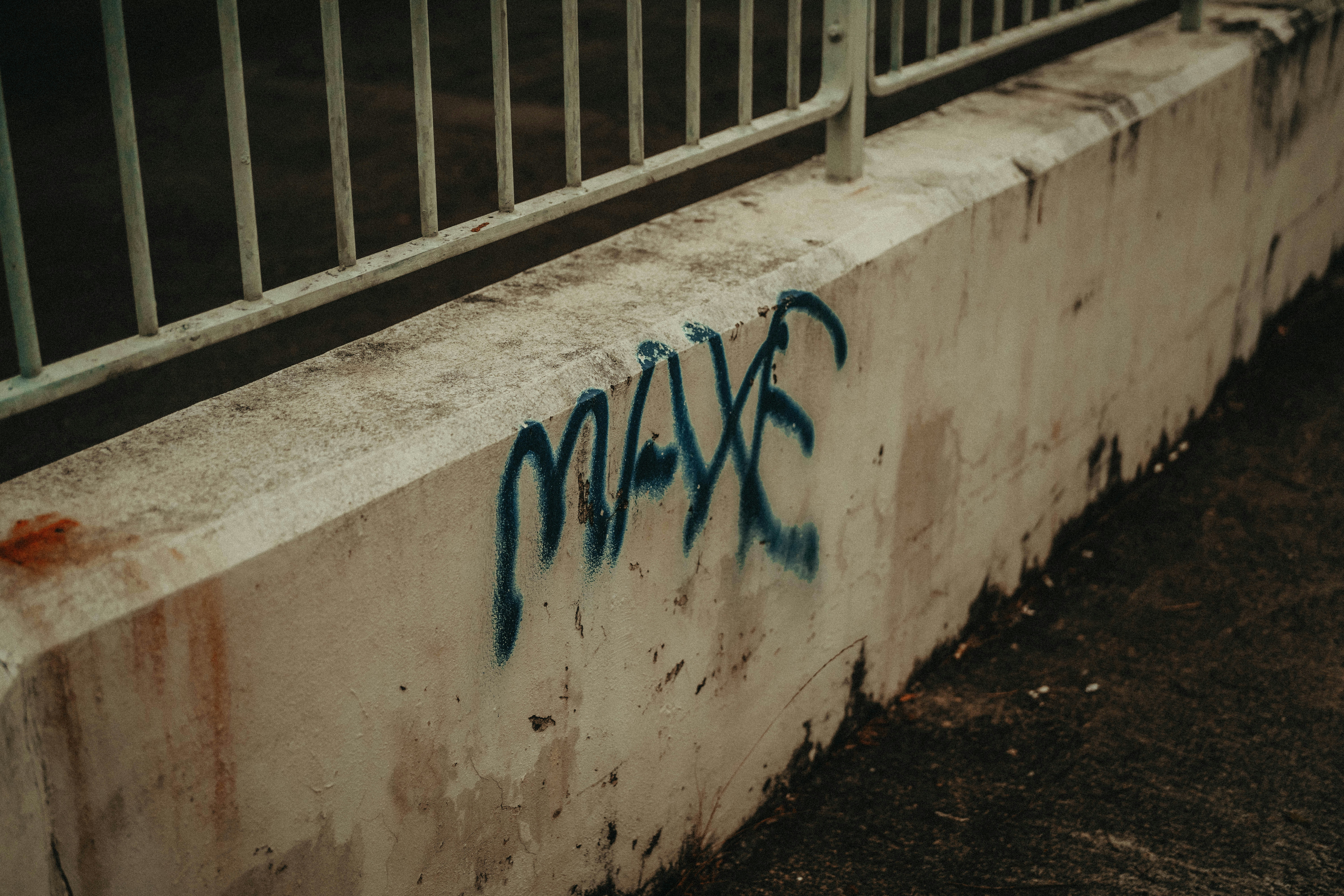 a concrete wall with blue graffiti on it