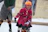 A joyful child learning to skate with a supportive instructor in a sunny park.