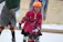 A joyful child learning to skate with a supportive instructor in a sunny park.