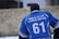 A person is seen from behind wearing a blue sports jersey with the text 'Himalayan Hawks Drass' and the number 61. The person is also wearing a black beanie. The background appears to be an outdoor setting.