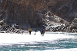 Adventurous hikers crossing a pristine river with rocky banks
