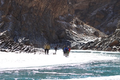 Adventurers crossing a crystal-clear river during an exciting trekking expedition.