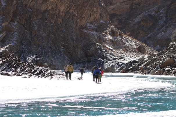 Hikers crossing a wooden bridge over a rushing river in the heart of the Carretera Austral.