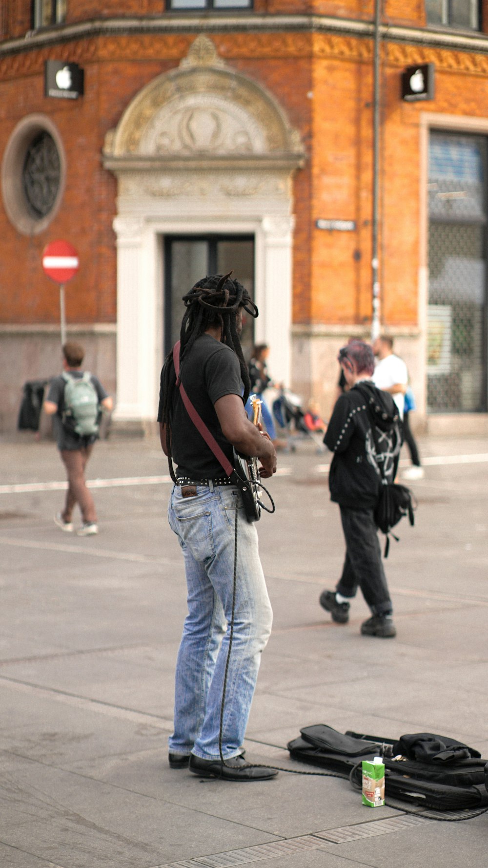 a man with dreadlocks standing in front of a building