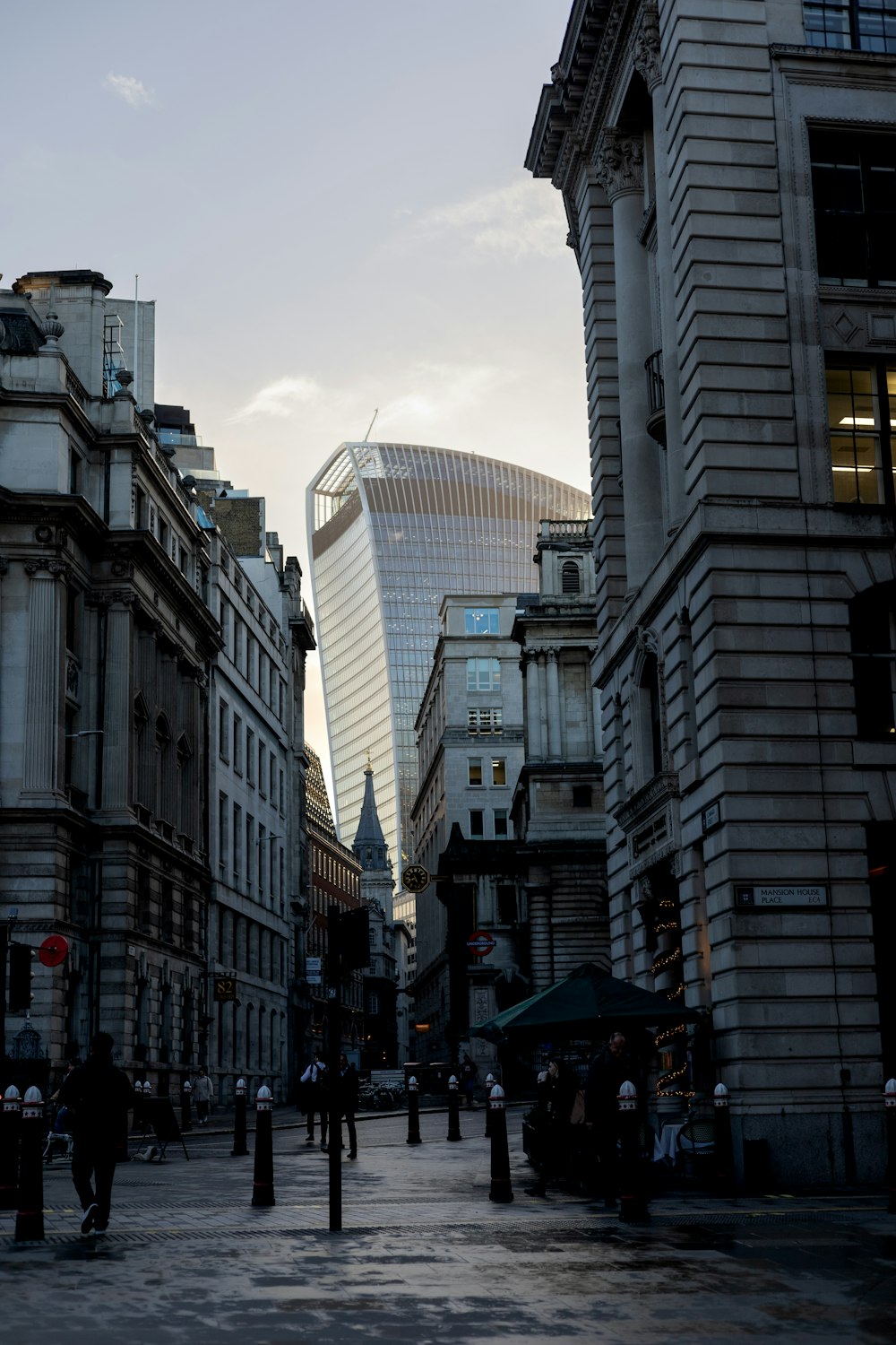 a group of people walking down a street next to tall buildings