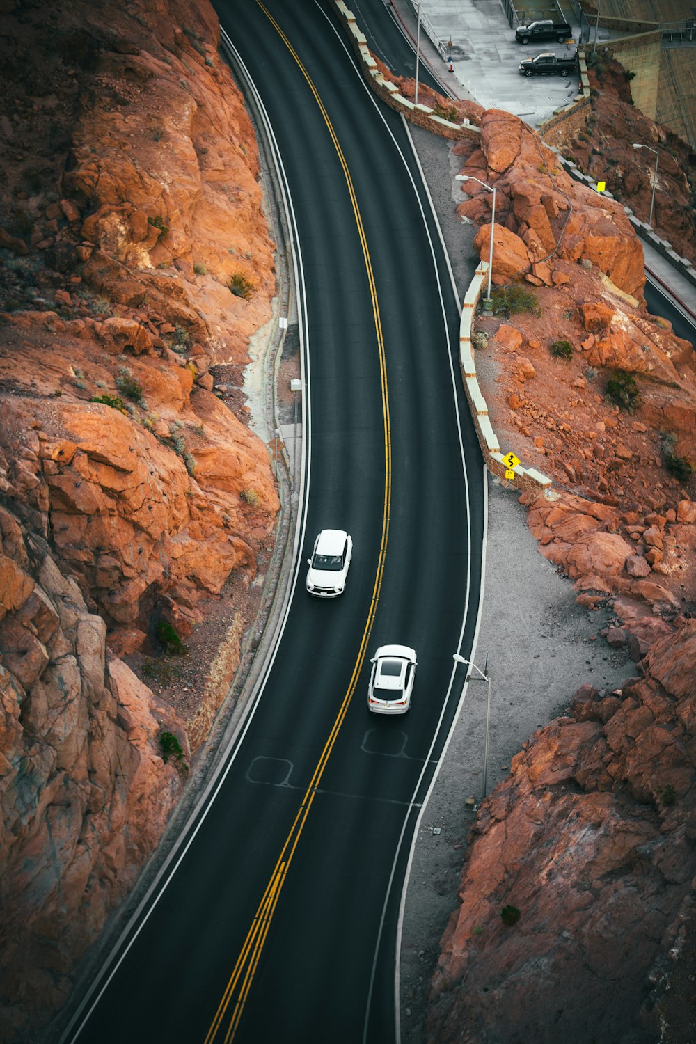 a couple of cars driving down a mountain road