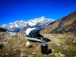 Helmet and gloves laid out on a wooden table with mountain background