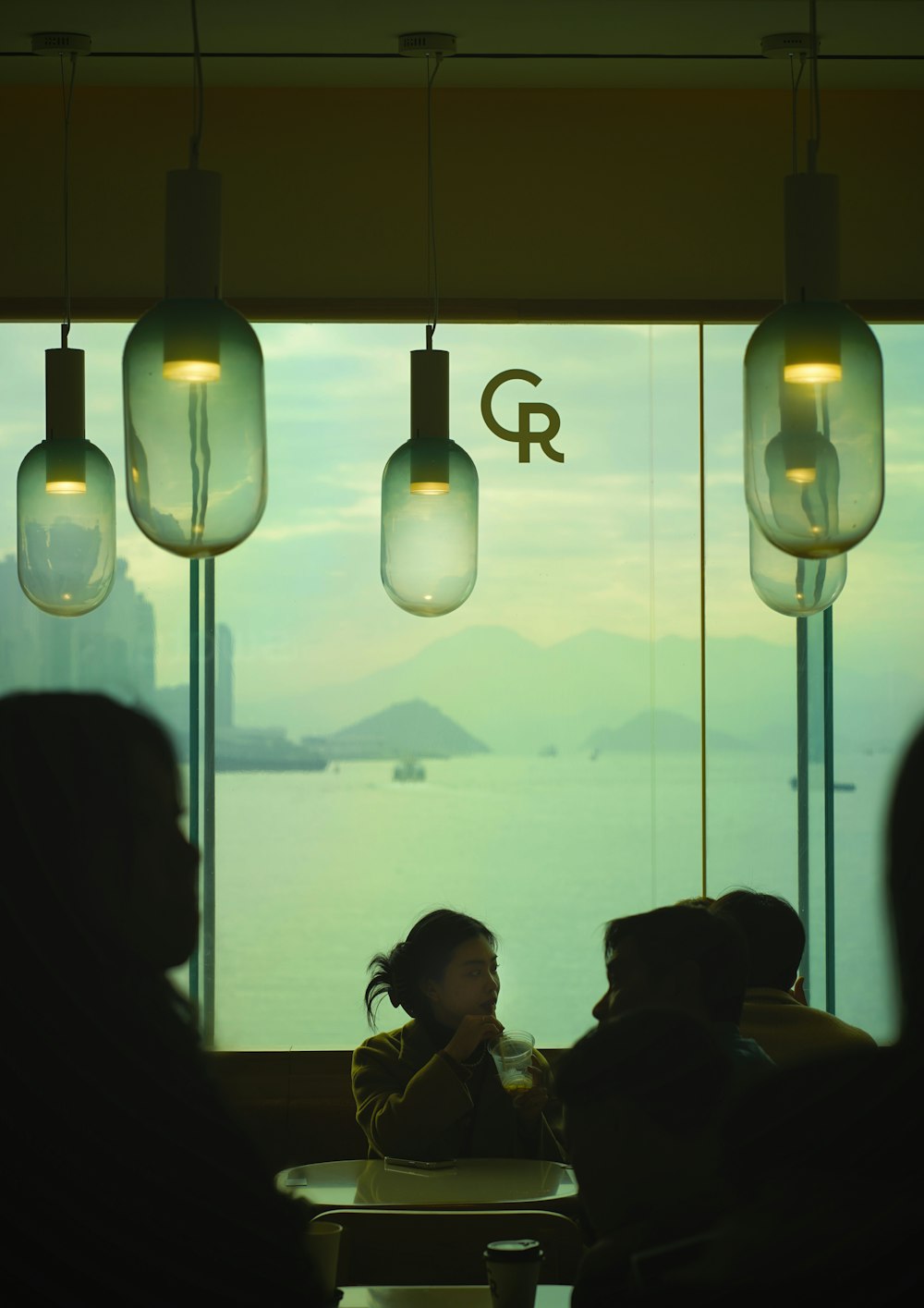 a group of people sitting at a table in front of a window