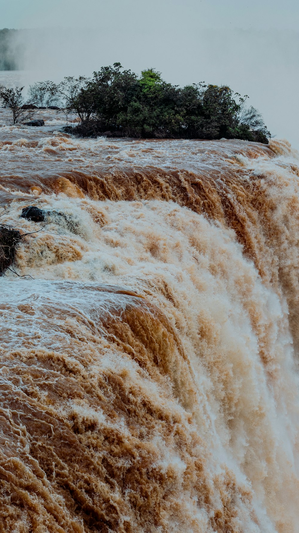 ein großer Wasserfall mit einer kleinen Insel in der Mitte