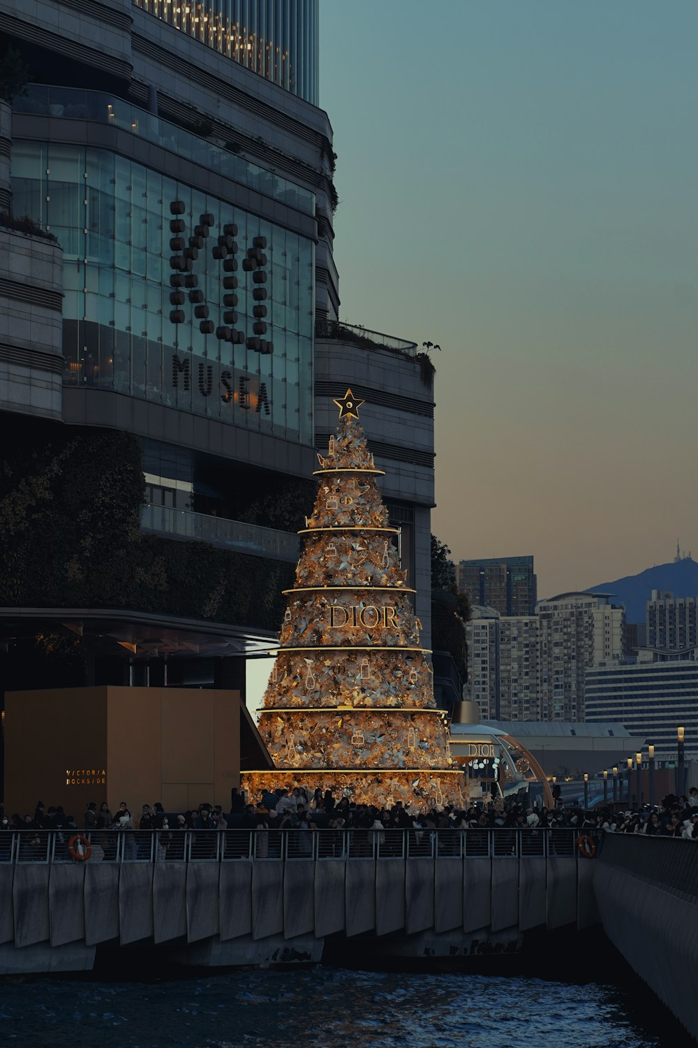 a very tall christmas tree sitting in the middle of a river