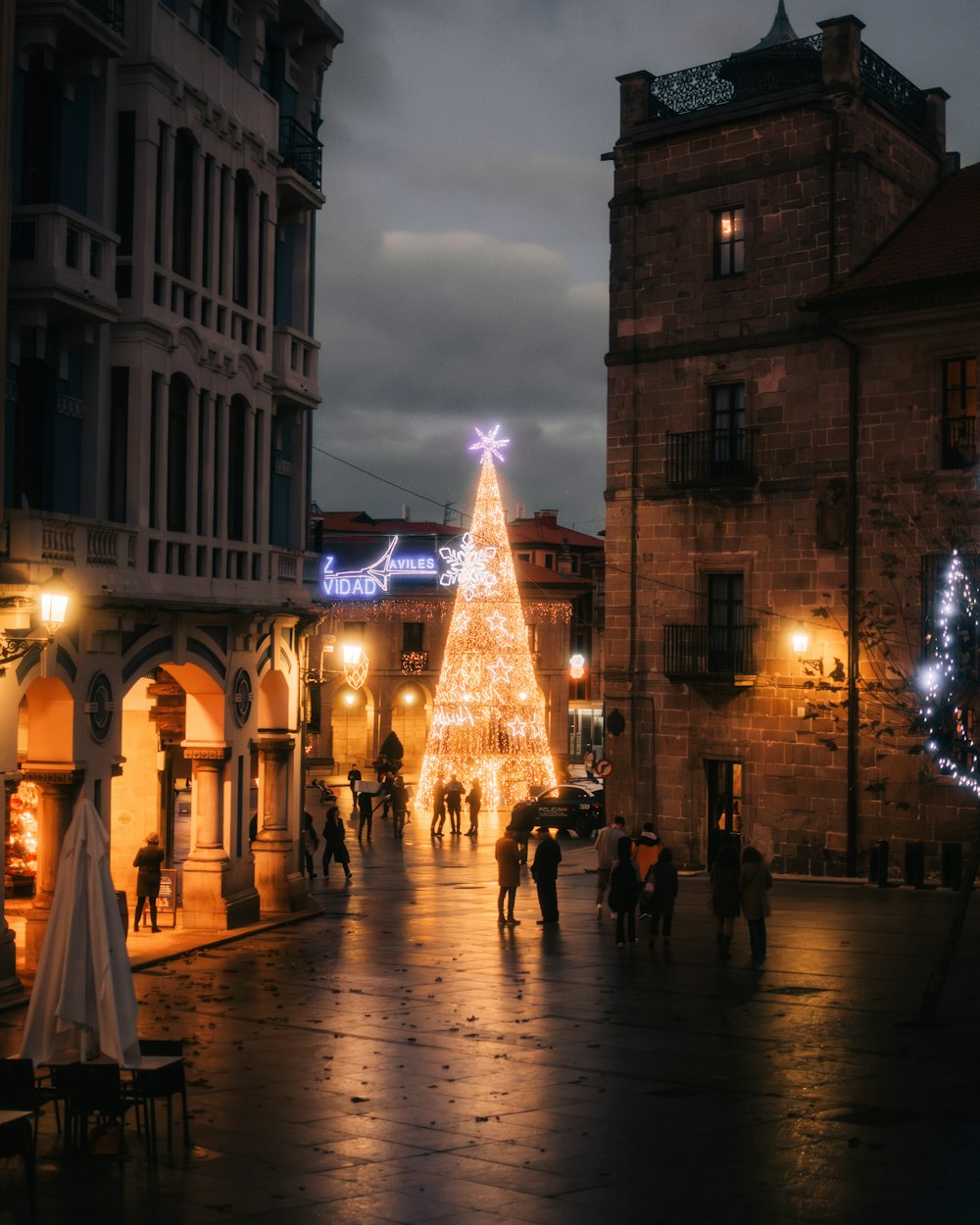 a christmas tree is lit up in the middle of a street