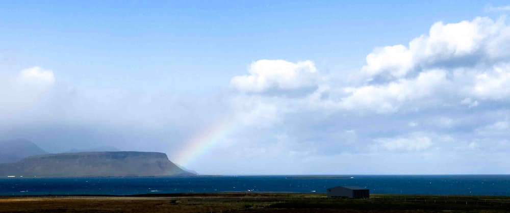 ein Regenbogen am Himmel über einem Gewässer