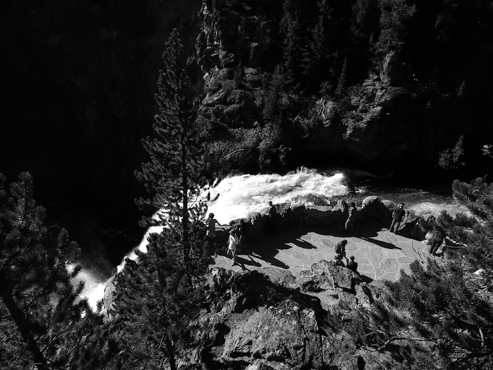 a black and white photo of a group of people hiking up a mountain