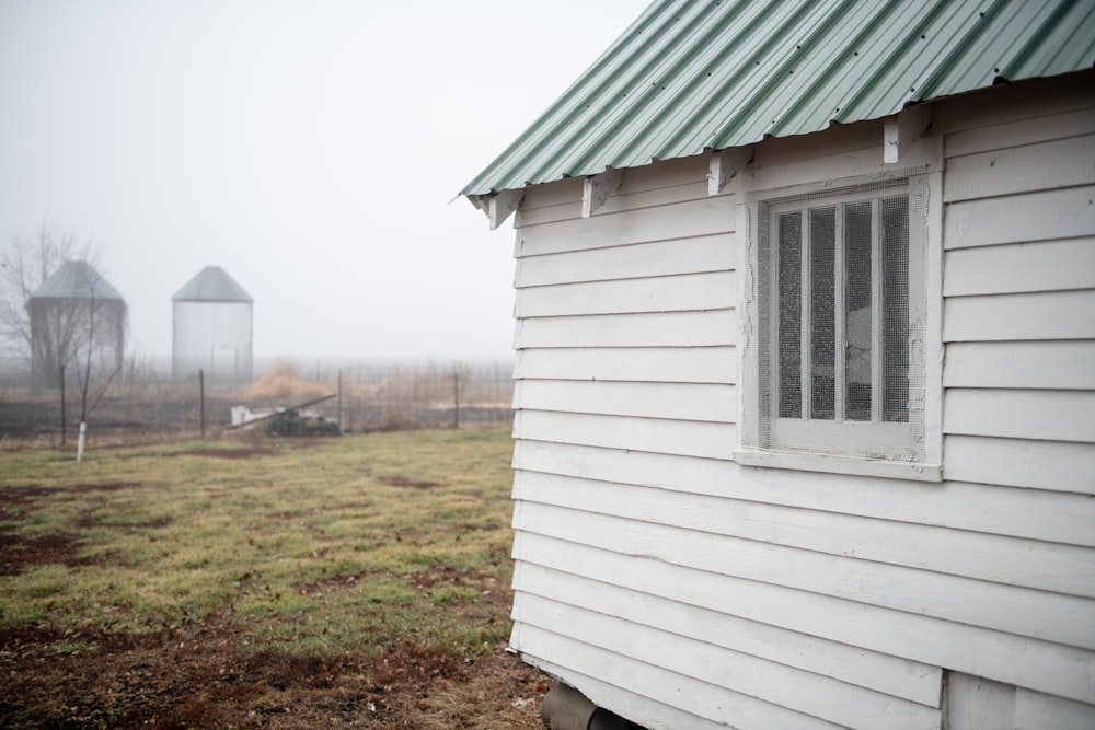 a small white house with a green roof