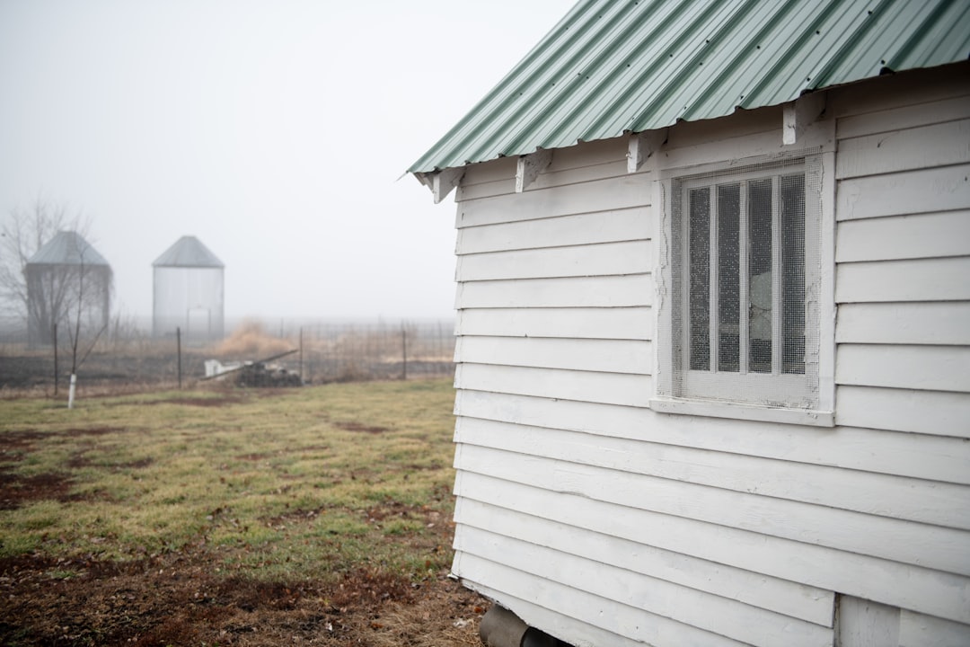 a small white house with a green roof,