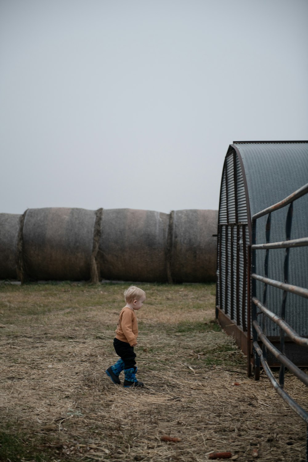 a little boy that is standing in the dirt