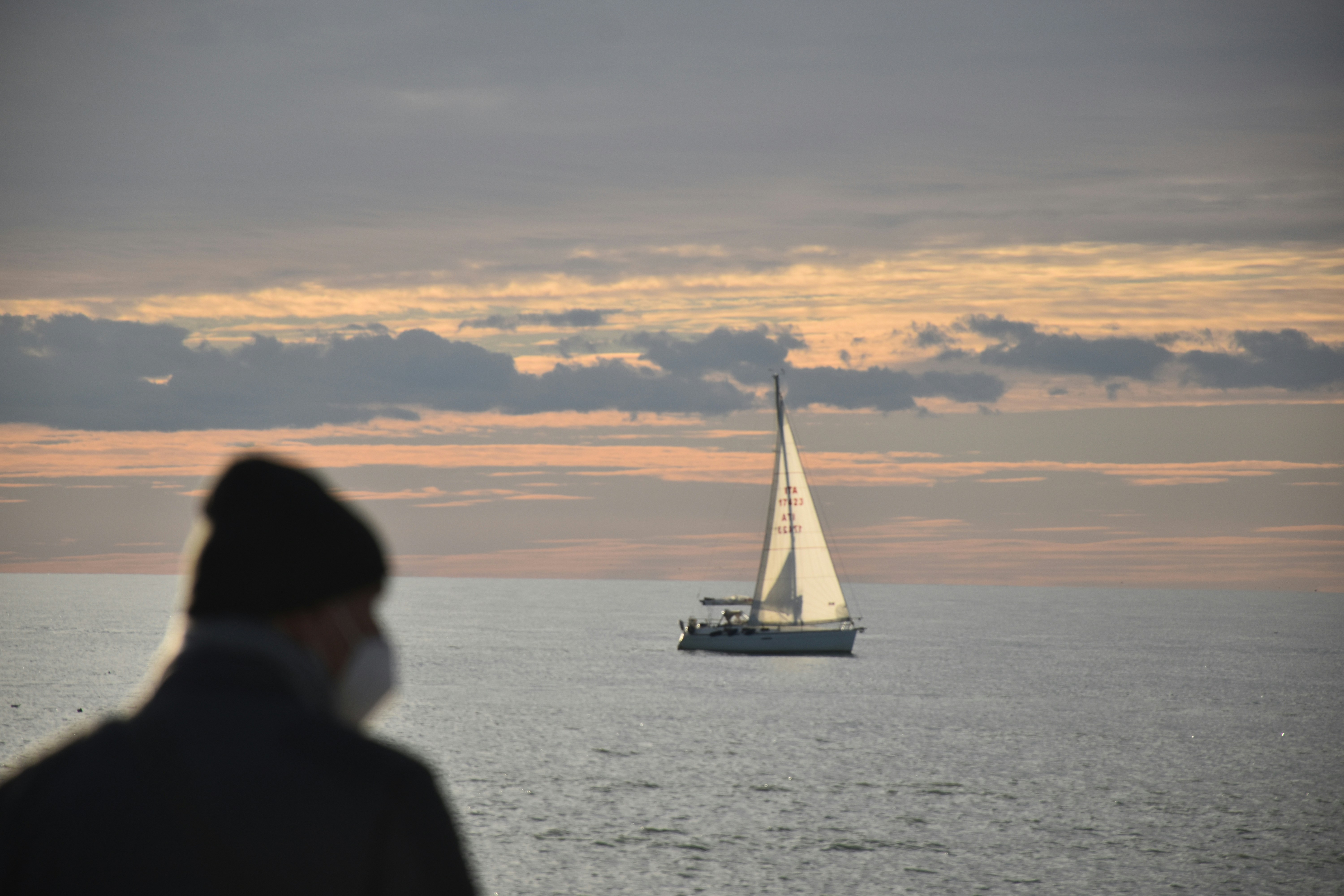 a man standing in front of a sailboat in the ocean (Photo by Federico Calcinai on Unsplash)